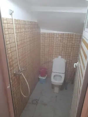 a small bathroom with a toilet and a shower at Ecogite La Tourterelle - Guesthouse in Kalaat MGouna
