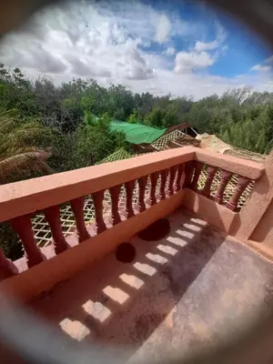 a wooden balcony with a view of a golf course at Ecogite La Tourterelle - Guesthouse in Kalaat MGouna