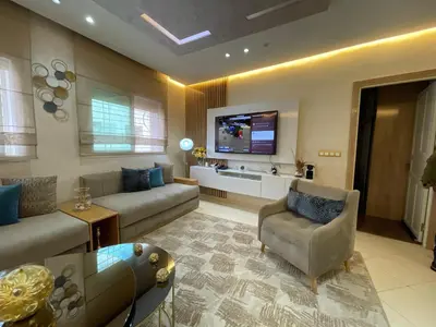 a living room with a couch and a tv at Luxury Apartment Fes - Premium Area in Fès