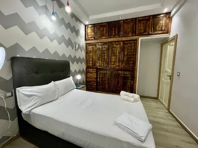 a bedroom with a large bed with white sheets at Luxury Apartment Fes - Premium Area in Fès