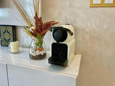 a coffee maker on a counter with a vase of flowers at Luxury Apartment Fes - Premium Area in Fès