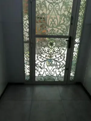 an open glass door with a window with a gate at Entire home in Tangier, Morocco in Oulad Akkou