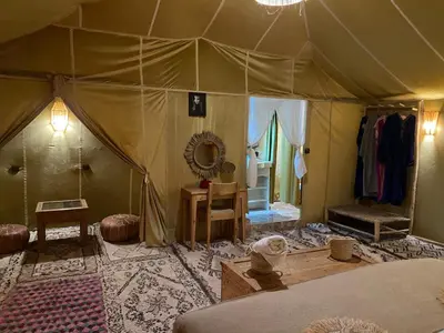 a room with a tent with a bed and a mirror at DesertGlow camp in Merzouga