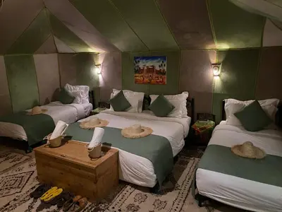a room with three beds with hats on them at DesertGlow camp in Merzouga