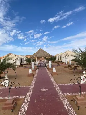 a walkway leading to a compound with tents at DesertGlow camp in Merzouga