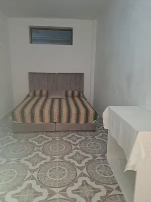 a bedroom with a bed on a floor with a table at اقامااات رضى in Aït Saïd