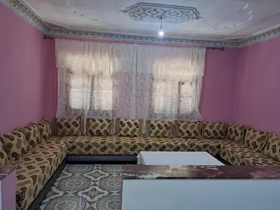 a couch in a living room with pink walls at اقامااات رضى in Aït Saïd