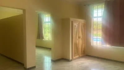an empty room with two windows and a door at Auberge nadia in Sefrou