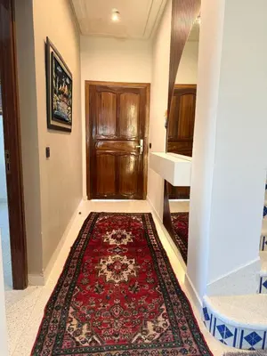 a hallway with a rug and a wooden door at Maison De Maitre in Fès