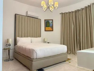 a bedroom with a large white bed and a chandelier at Maison De Maitre in Fès