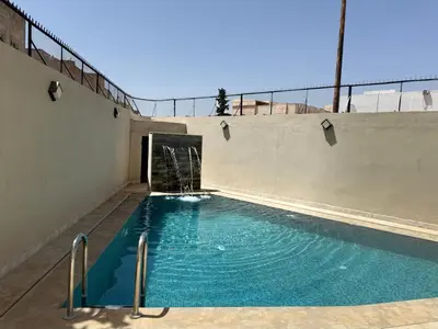 an empty swimming pool with a water fountain at Maison De Maitre in Fès