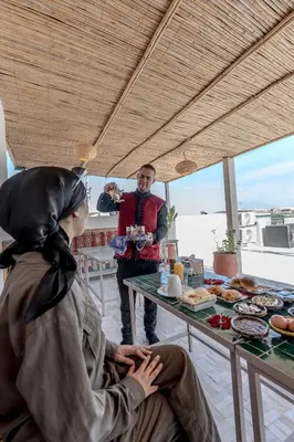 a man standing in front of a table of food at Riad Al Mozyane in Fès