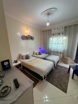 a hotel room with two beds and a table at Appartement cosy à Fès in Fès