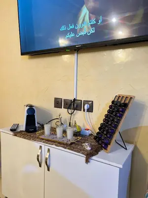 a table with a bunch of wine glasses and a tv at Appartement cosy à Fès in Fès