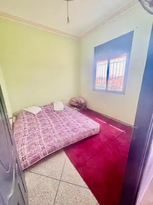 a bedroom with a pink bed and a red carpet at Tinzouline in Tinzouline