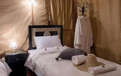 a bedroom with a bed with towels on it at Shahrazad Nights Desert Camp in Merzouga
