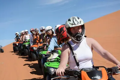 a group of people riding on quad bikes in the desert at Shahrazad Nights Desert Camp in Merzouga