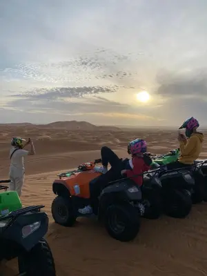 a group of people riding atvs in the desert at Shahrazad Nights Desert Camp in Merzouga
