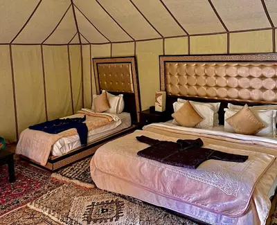 a bedroom with two beds in a tent at Staying Desert Luxury Camp in Merzouga