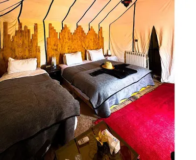 a bedroom with two beds in a tent at Staying Desert Luxury Camp in Merzouga