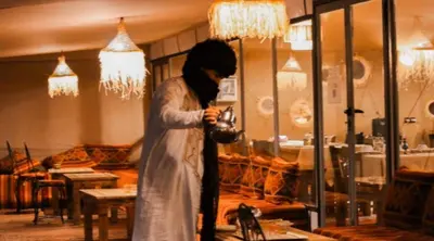 a woman standing in a store looking at her cell phone at Staying Desert Luxury Camp in Merzouga