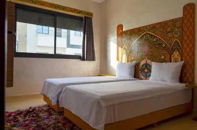 a bedroom with a bed with a headboard and a window at Appartement Nadine Fès in Fès