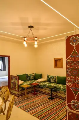 a living room with green couches and a rug at Appartement Nadine Fès in Fès