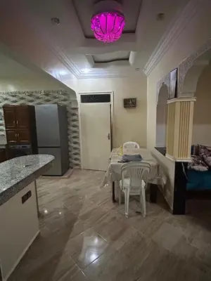 a kitchen with a table and chairs and a pink light at Appartement à louer 67 m à Safi in Oulad Akkou