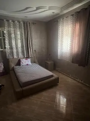 a bedroom with a bed in a room with windows at Appartement à louer 67 m à Safi in Oulad Akkou