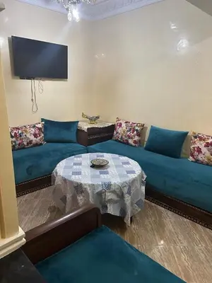 a living room with a blue couch and a table at Appartement à louer 67 m à Safi in Oulad Akkou
