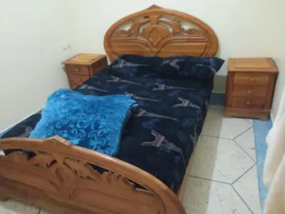 a bedroom with a wooden bed and two night stands at House of Dreams in Khenifra