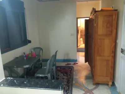 a living room with a table and a wooden cabinet at House of Dreams in Khenifra