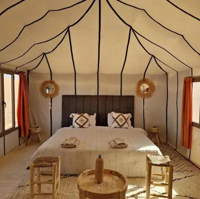 a bedroom with a large bed in a tent at Arawan Luxury Desert Camp at Erg Lihoudi in Mhamid