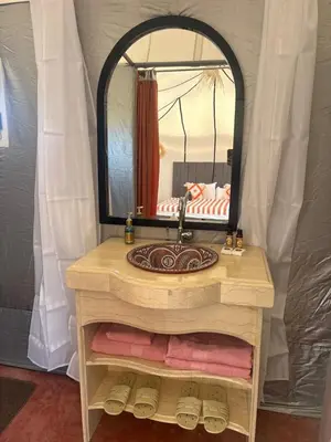 a bathroom with a sink and a mirror at Arawan Luxury Desert Camp at Erg Lihoudi in Mhamid
