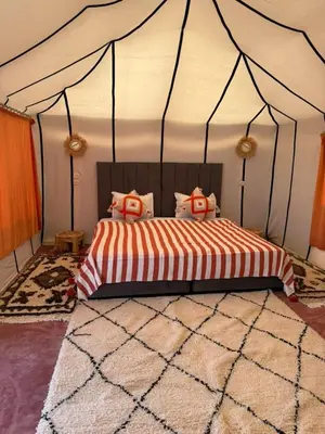 a bedroom with a bed in a tent at Arawan Luxury Desert Camp at Erg Lihoudi in Mhamid