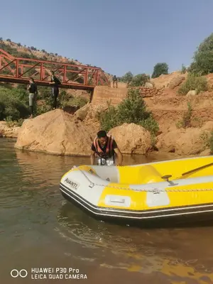 a man standing next to a boat in the water at Appart à merjane in Meknès