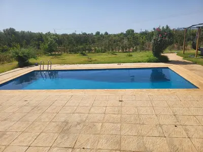 a swimming pool with blue water in a yard at Villa avec piscine in Meknès