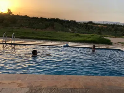 two people are swimming in a swimming pool at Villa avec piscine in Meknès
