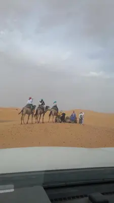 a group of people riding horses in the desert at Tenere luxury camp in Merzouga