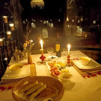 a table with a plate of food and two candles at Tenere luxury camp in Merzouga