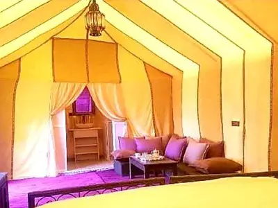 a room with a bed and a couch and a table at Tenere luxury camp in Merzouga