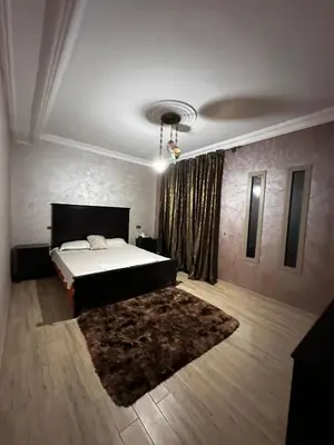a bedroom with a large bed and a rug at Villa avec piscine in Meknès