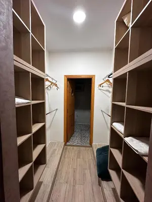 a walk in closet with wooden shelves and a hallway at Villa avec piscine in Meknès