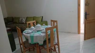 a dining room table with chairs and a couch at La maison verte in Fès