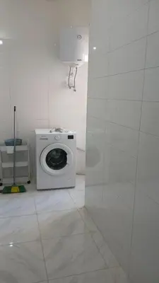 a white bathroom with a washing machine in a room at La maison verte in Fès