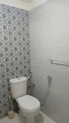 a bathroom with a toilet and a tile wall at La maison verte in Fès