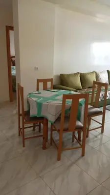 a table and chairs with a couch in a living room at La maison verte in Fès