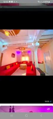 a living room with a red couch and purple lights at Location de vacance in Azrou
