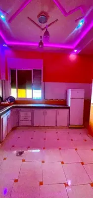 an empty kitchen with purple lights in a room at Location de vacance in Azrou