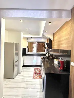 a kitchen with a black counter and a refrigerator at dar diyafa in Beni Mellal